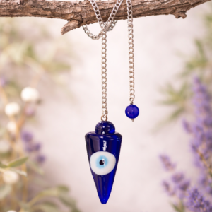 Evil Eye Pendulum divination hanging across a branch